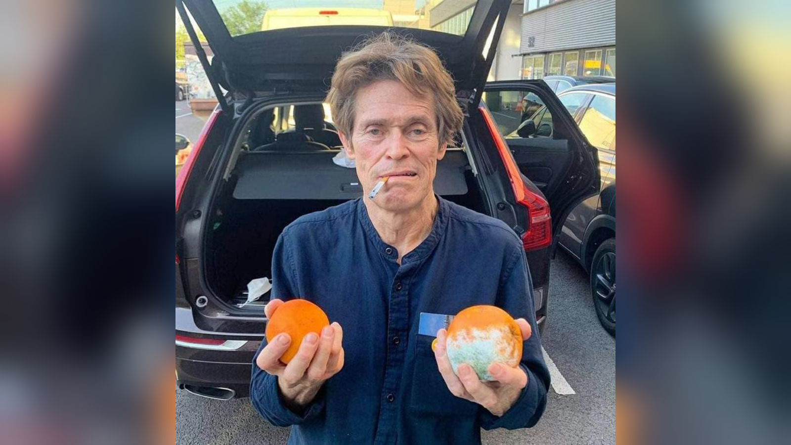 Willem Dafoe Smoking Cigarette With Two Oranges One of Them Moldy